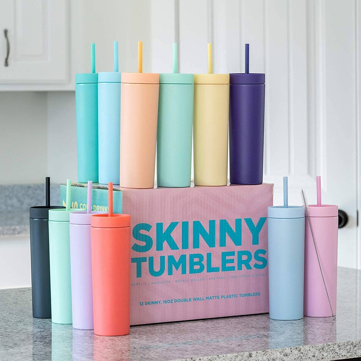 Assorted-color skinny tumblers with lids and straws, arranged in a row
