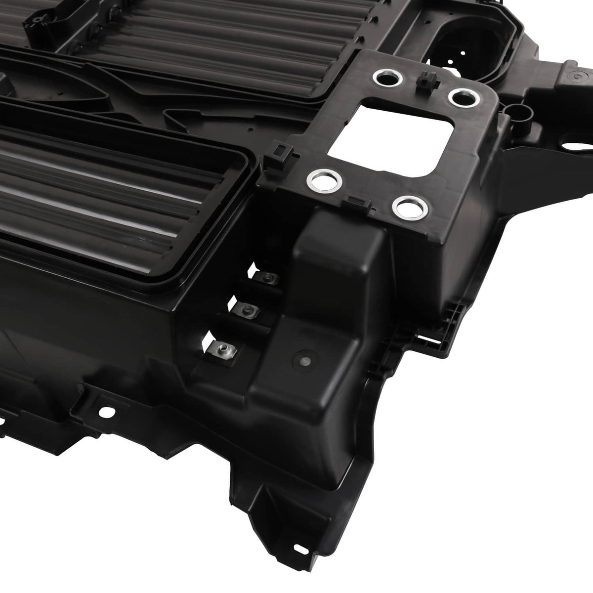 Close-up of black active grille shutter motor housing with mounting points and brackets