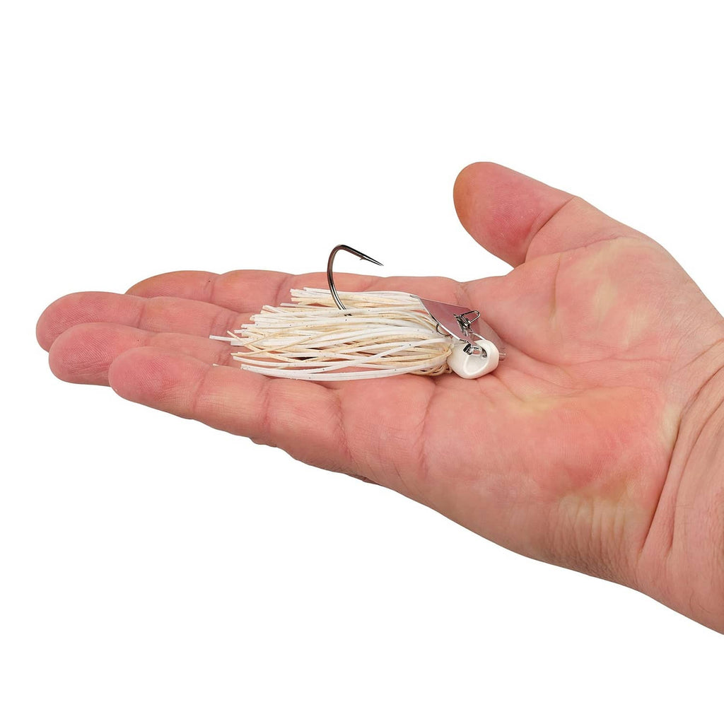 Bladed jig held in palm with white-and-tan skirt strands and curved hook
