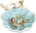 Ceramic lotus leaf jewelry tray with two white bird ring holders and gold-toned rings