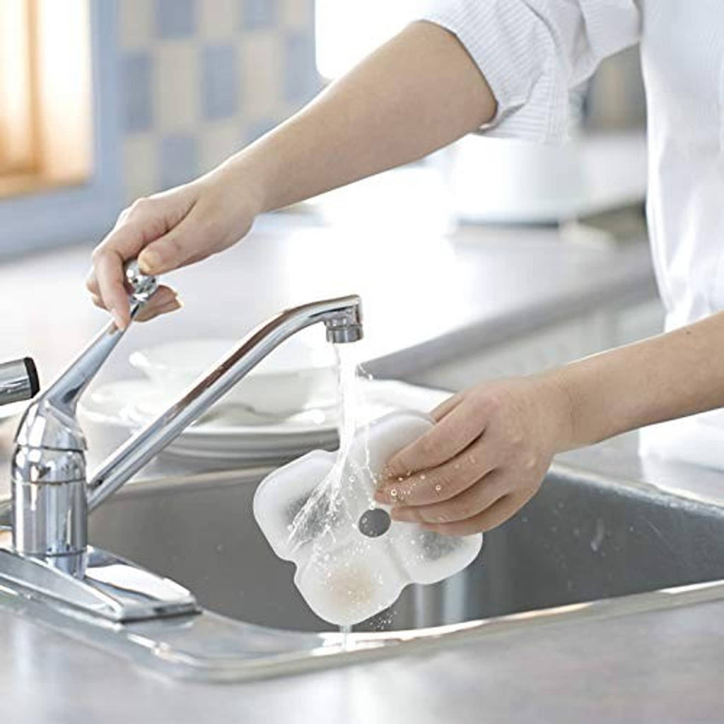 Cat fountain filter replacement pad being rinsed by hands in sink