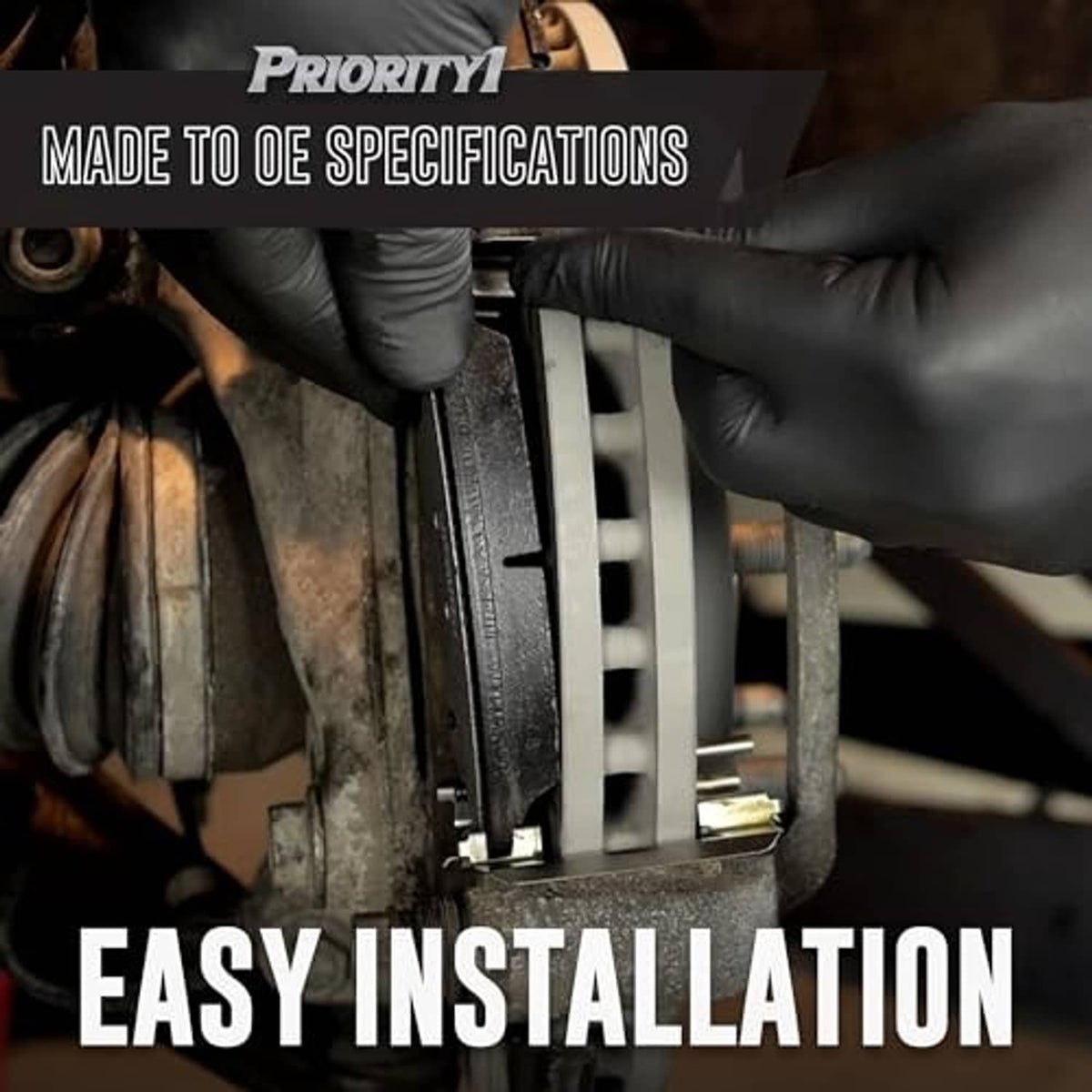 Rear brake pad installation with gloved hands holding a disc brake caliper