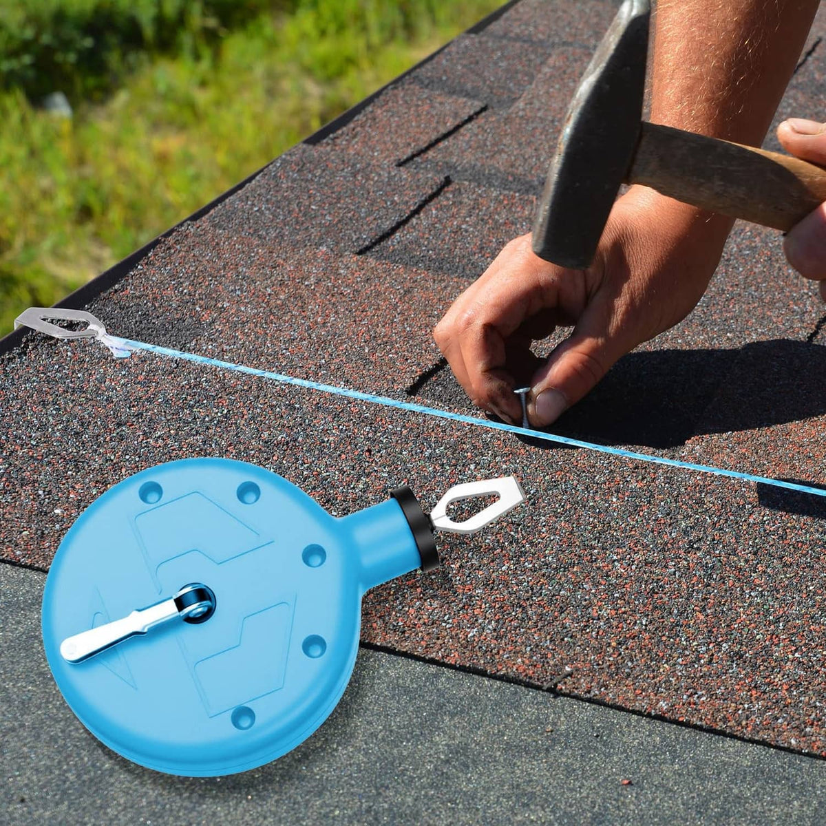 Blue chalk line reel tool with metal hook, used to mark a roof surface