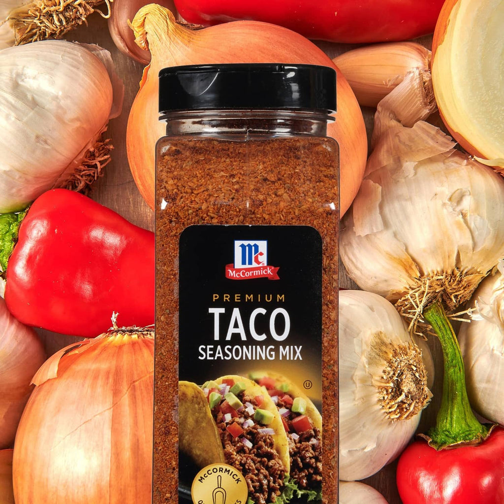 McCormick Premium Taco Seasoning Mix jar surrounded by onions, red peppers, and garlic