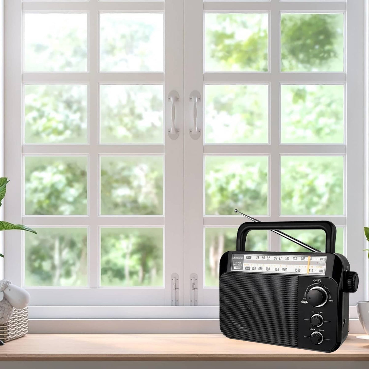Portable AM/FM radio by a window with the telescopic antenna raised