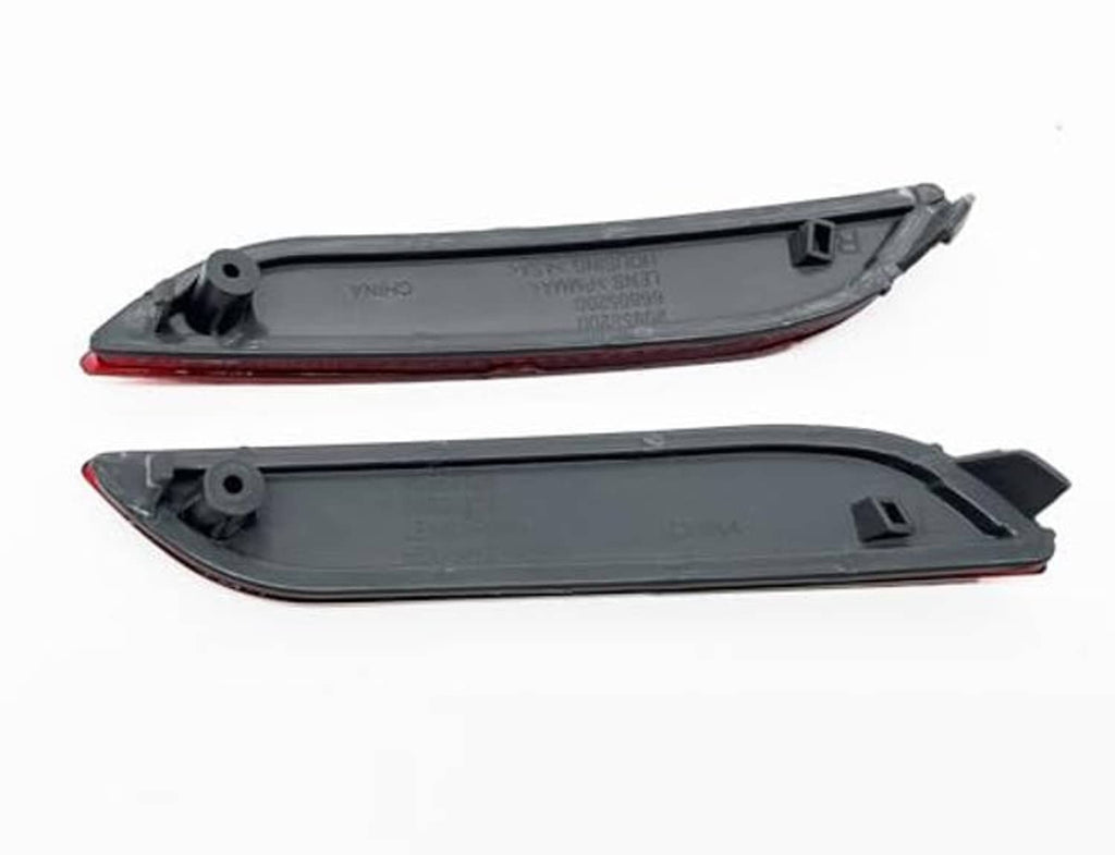 Two rear bumper reflector housings with mounting holes and tabs