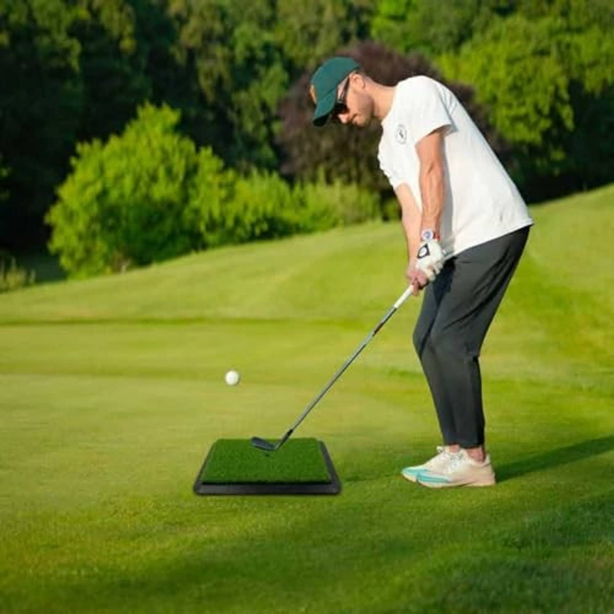 Golf practice mat on grass with green turf hitting area and tracking target lines