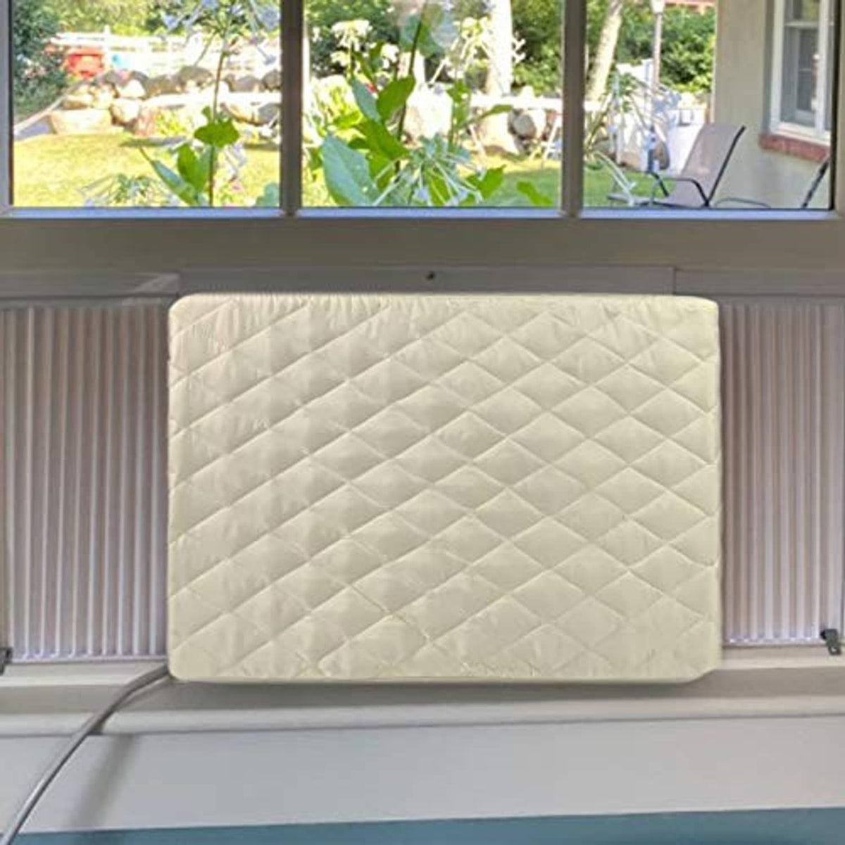 Cream quilted AC cover stretched over window AC between blinds