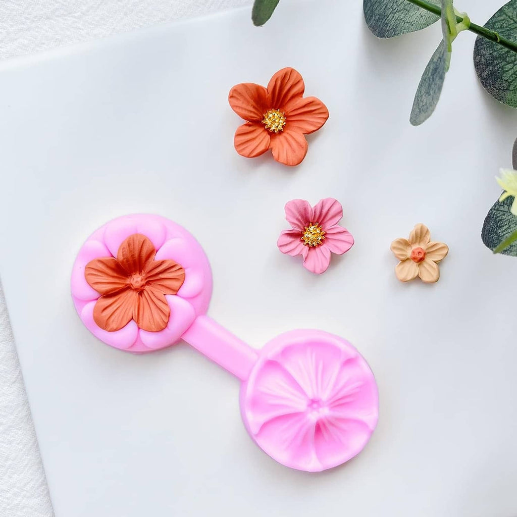 Pink flower petal cutter with orange, pink, and beige finished flower pieces