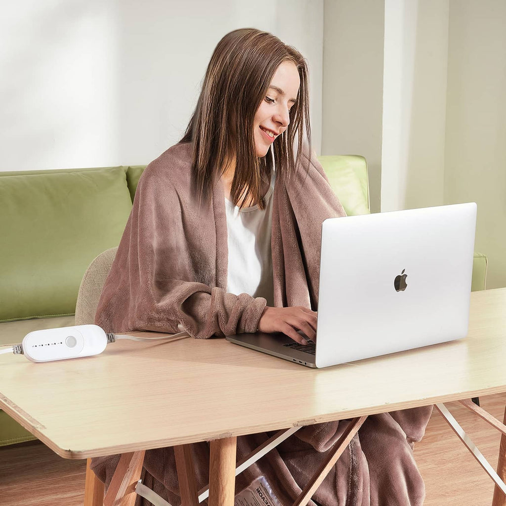 Taupe electric heated throw blanket in use with controller placed near a laptop