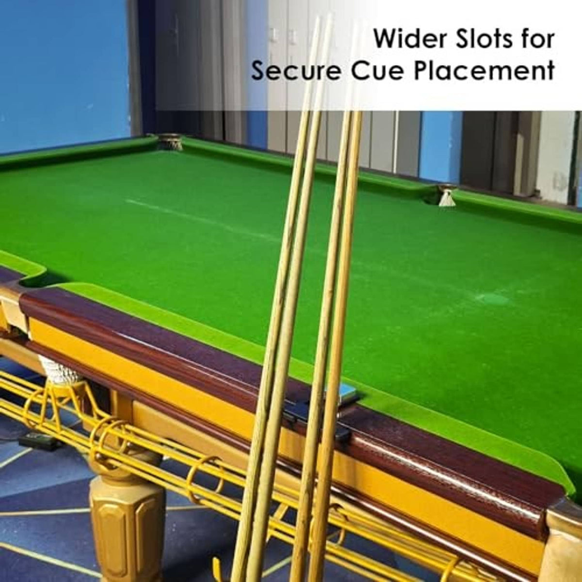 Black four-cue pool stick holder with silver weight placed on a billiard table