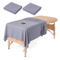 Gray massage table sheet set with circular face hole and neatly folded extras