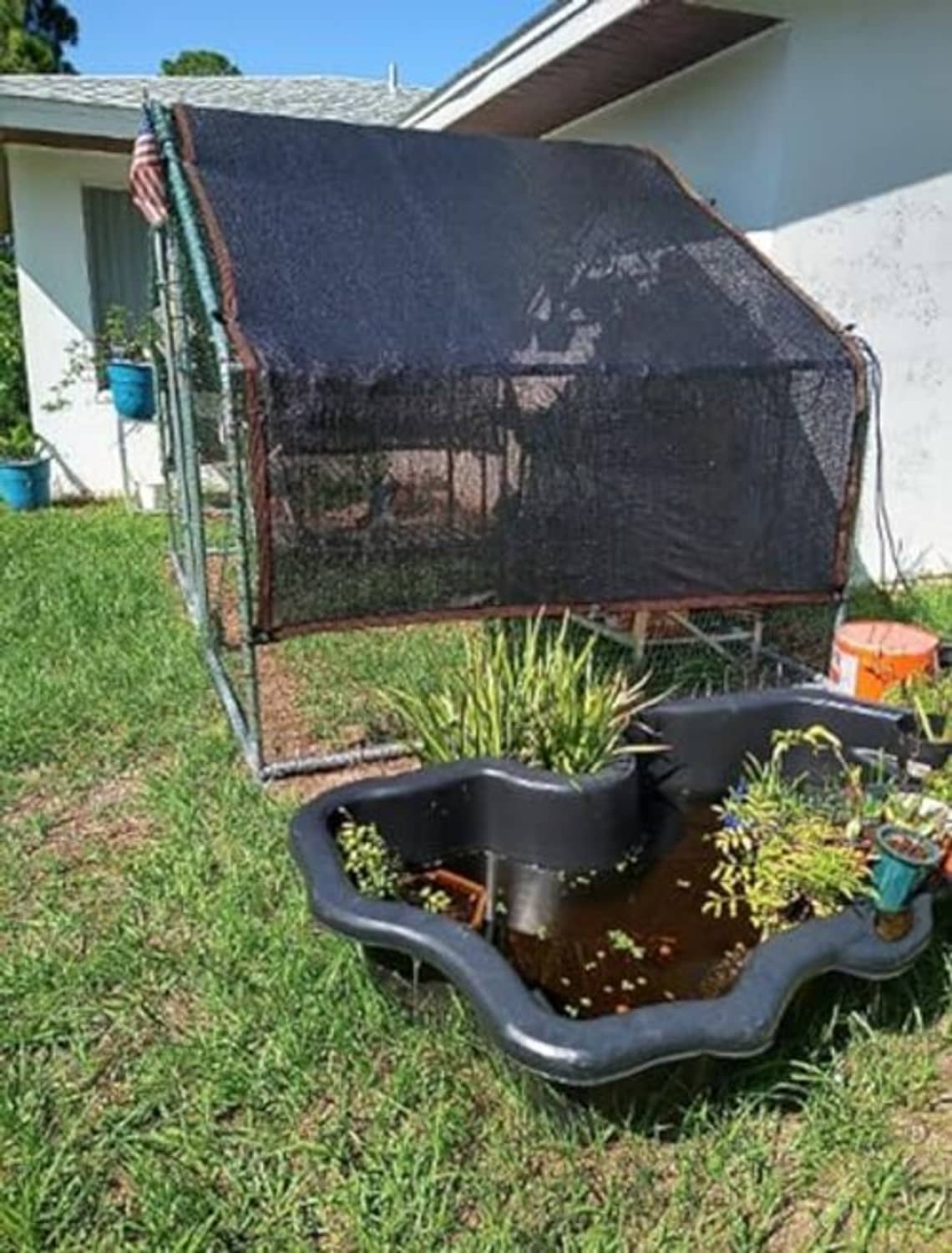 Outdoor shade mesh tarp covering a metal garden greenhouse frame