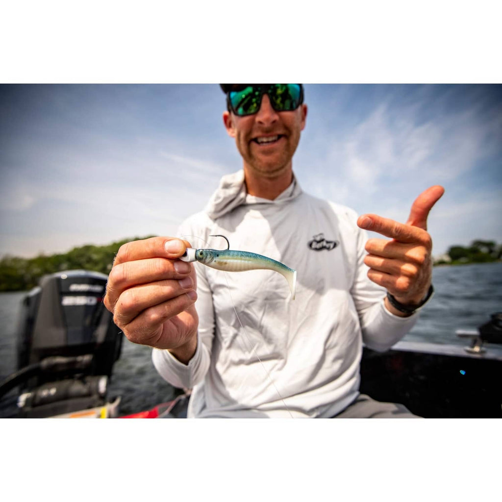 Lifelike minnow-style swimbait lure held in hand, blue-silver body with spots