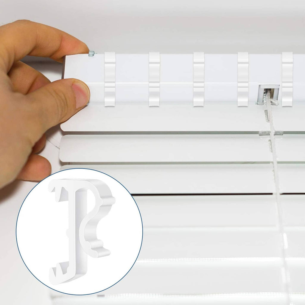 Hand installing a white blind valance clip onto a blind headrail