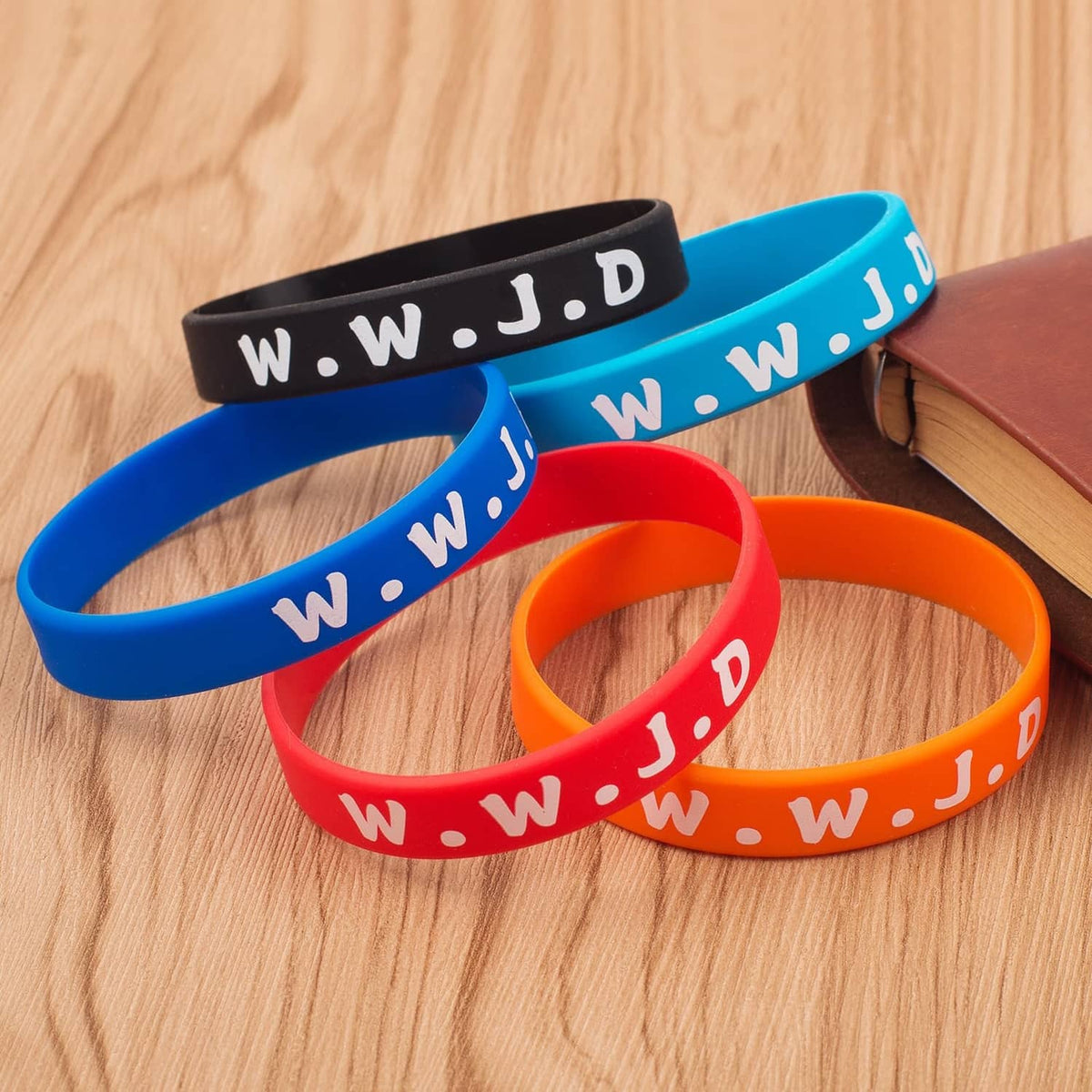 Colorful silicone wristbands in blue, red, and orange with white lettering