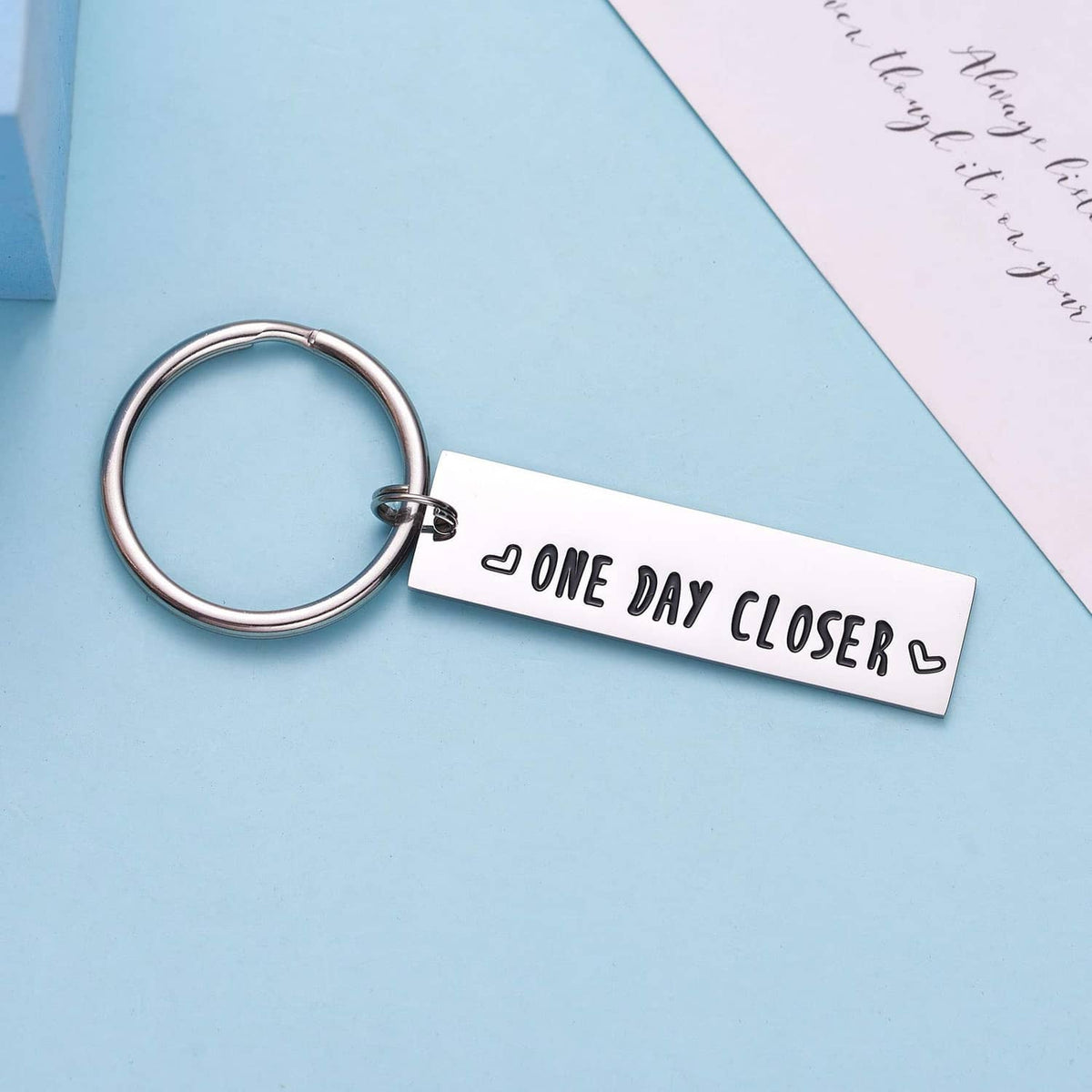Stainless steel keychain with 'ONE DAY CLOSER' engraving and small heart symbols
