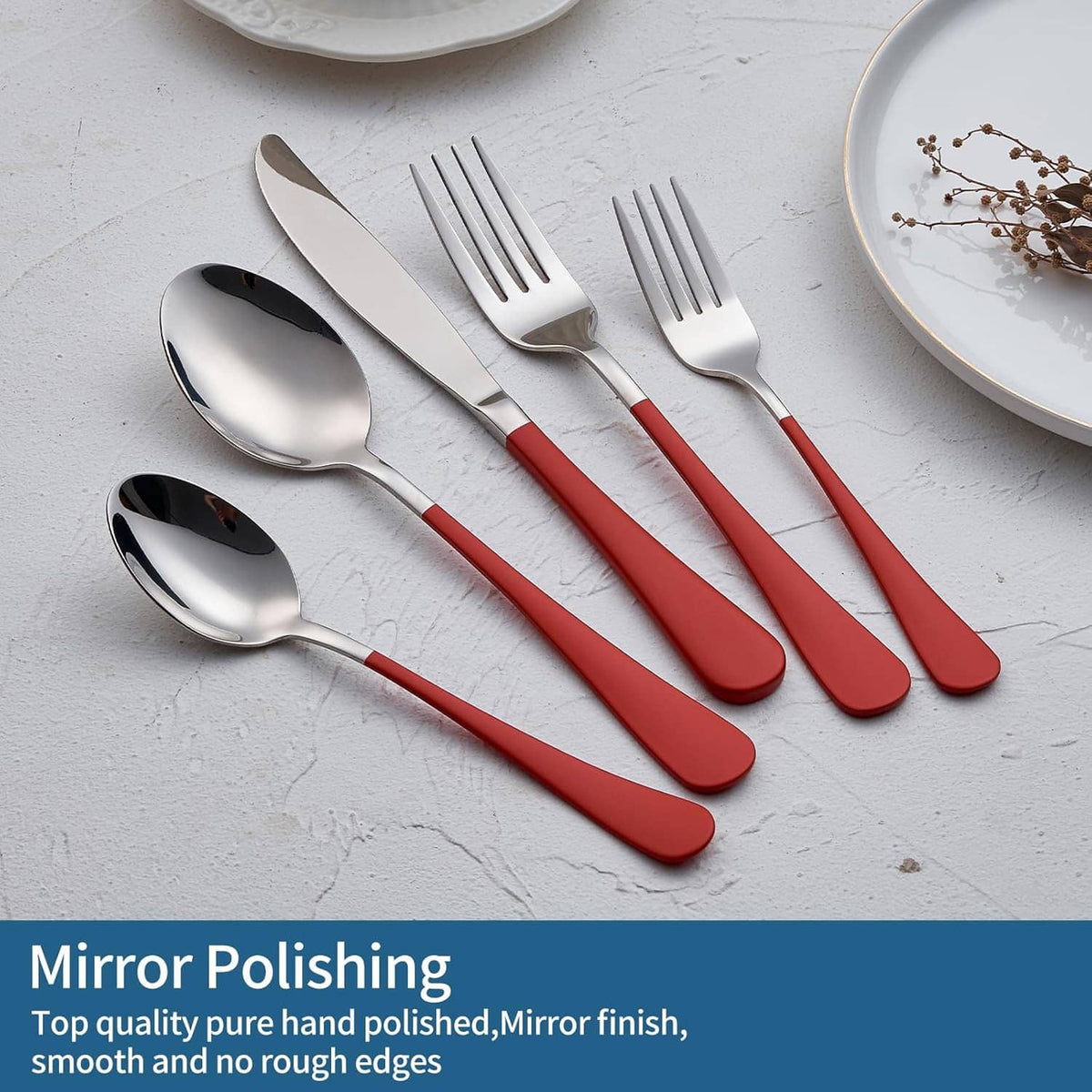 Red-handled stainless cutlery set with dinner knife, forks, and spoons on plates