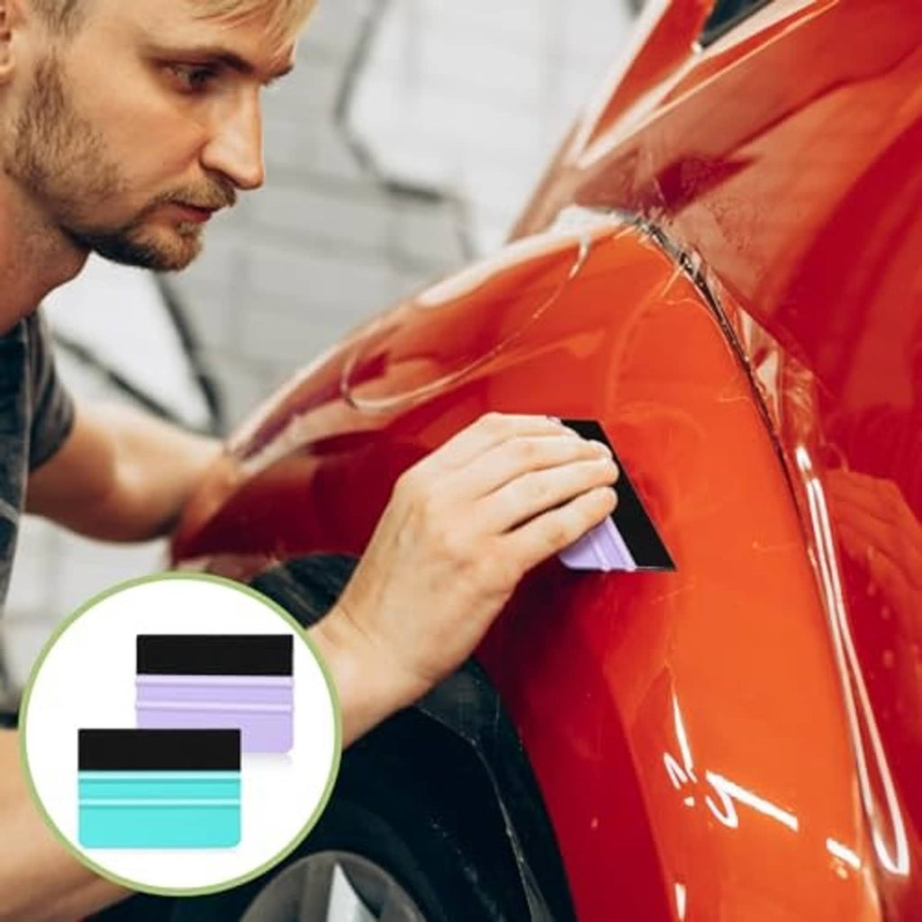 Man using turquoise squeegee with black felt edge to smooth vinyl film