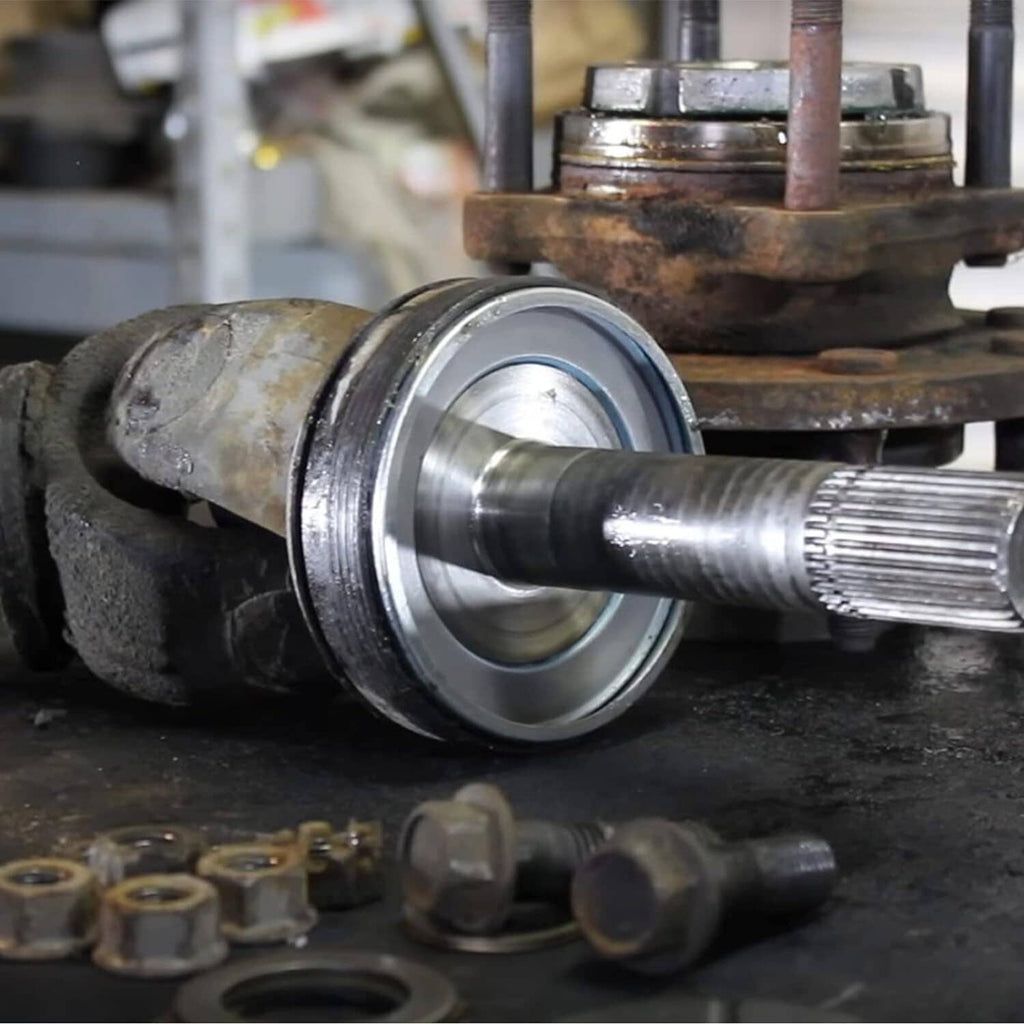 Front axle seal and greaseable U-joint kit installed on an axle shaft with bearing parts
