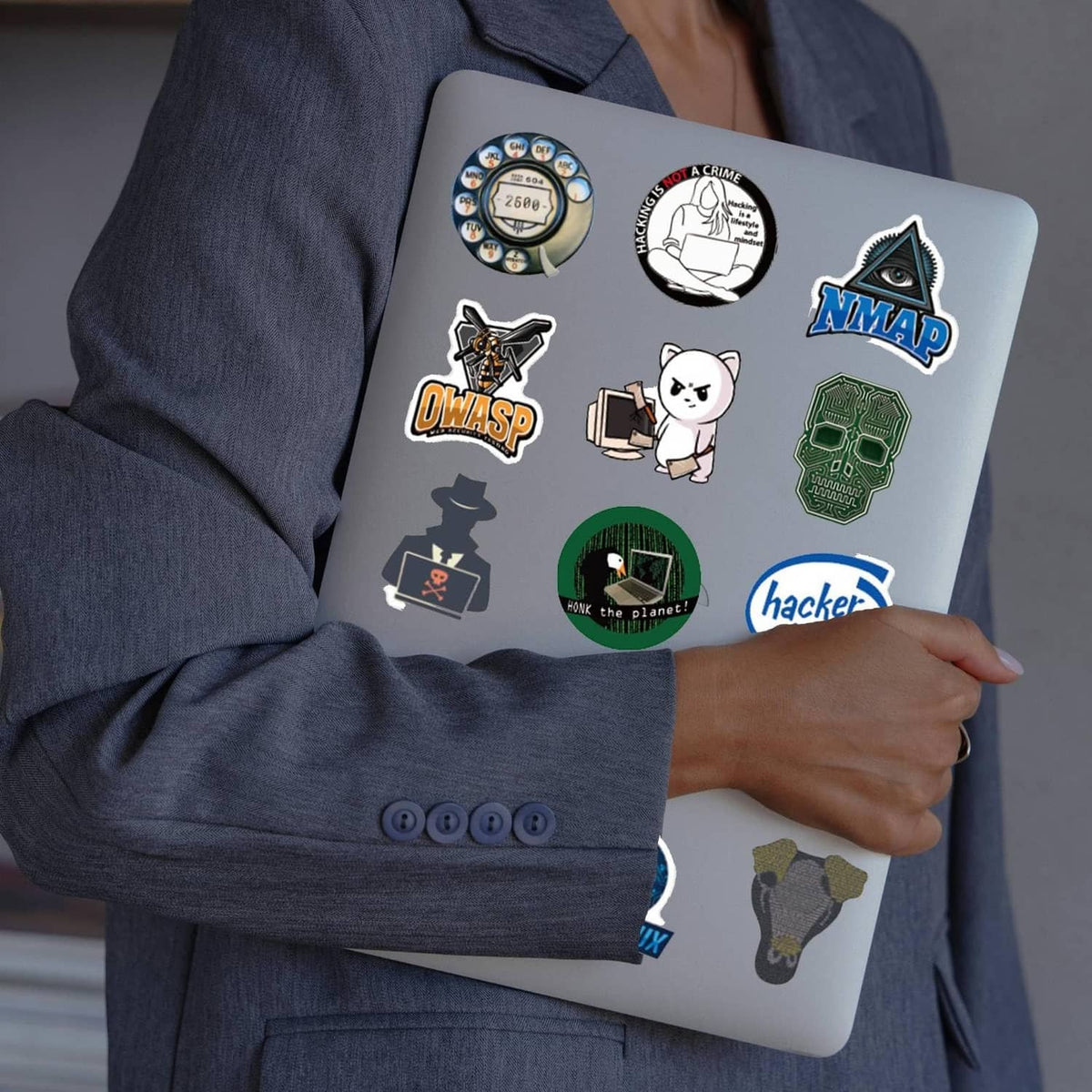Hacker-themed stickers on a light laptop cover with NMAP, ONWASP, and hacker cat icons