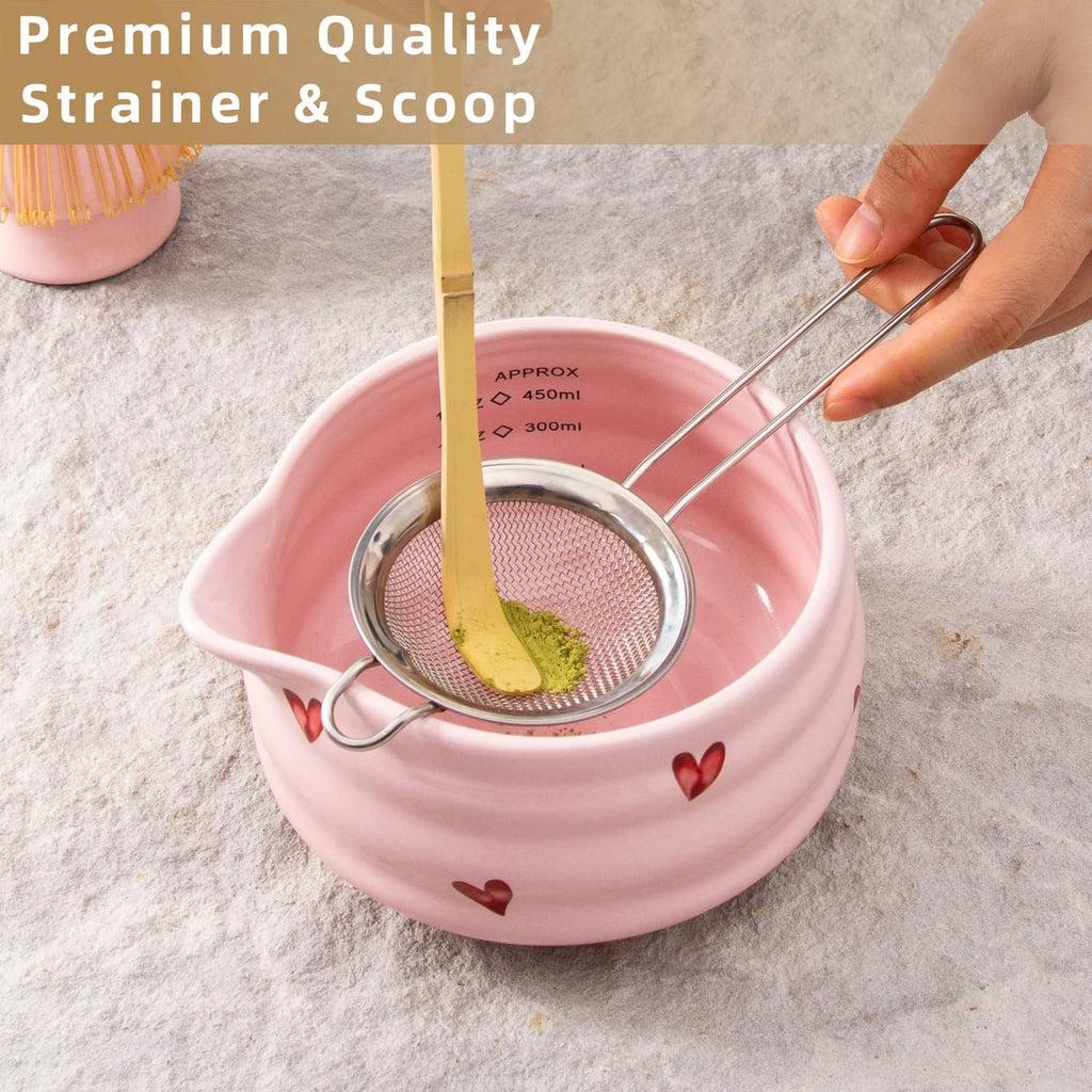 Stainless steel strainer in pink ceramic bowl with bamboo scoop
