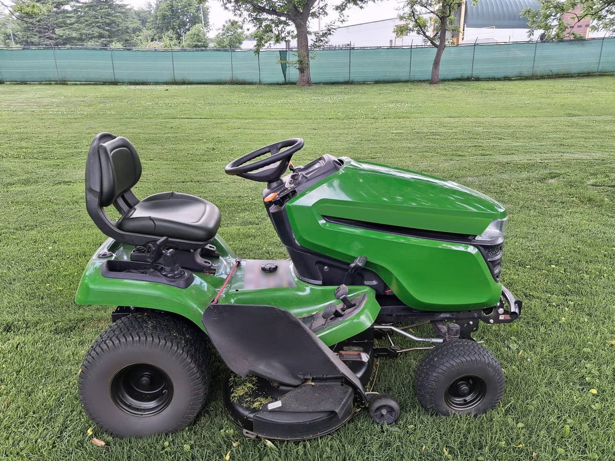 Green lawn tractor with upper hood, front grille, and headlight covers in black