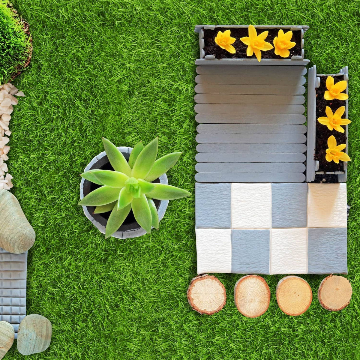 Green artificial grass mat pieces laid out, with succulents on the surface