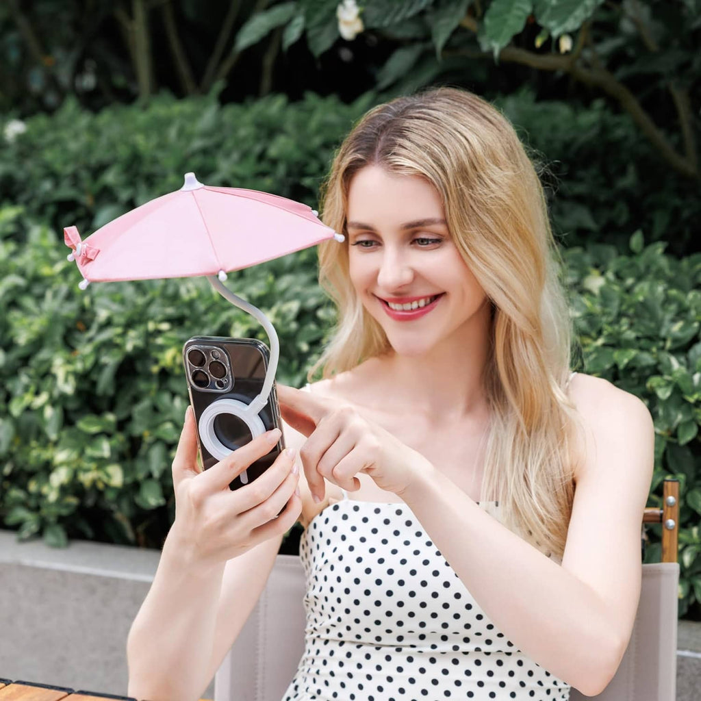 Pink magnetic phone umbrella with phone attachment, held outdoors with a smartphone.