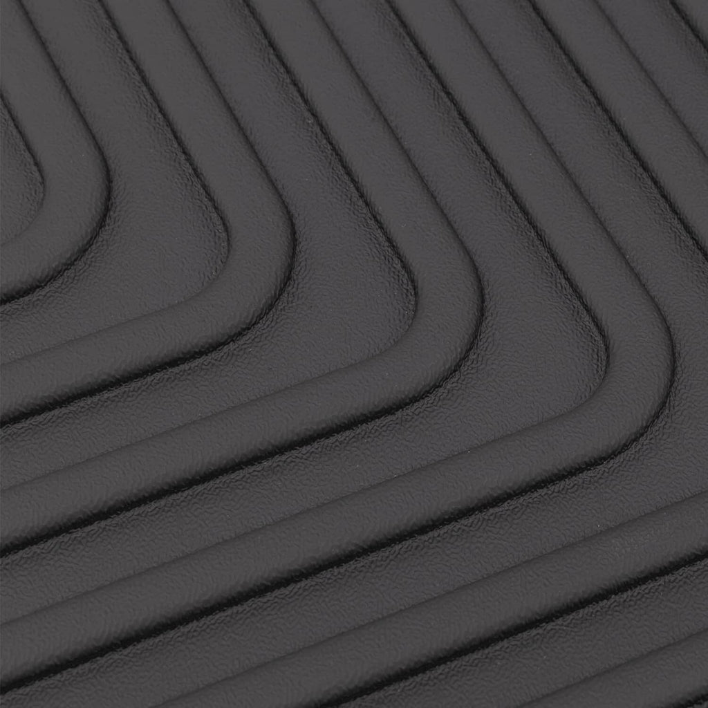 Black rubber floor mat with curved ridged grip channels