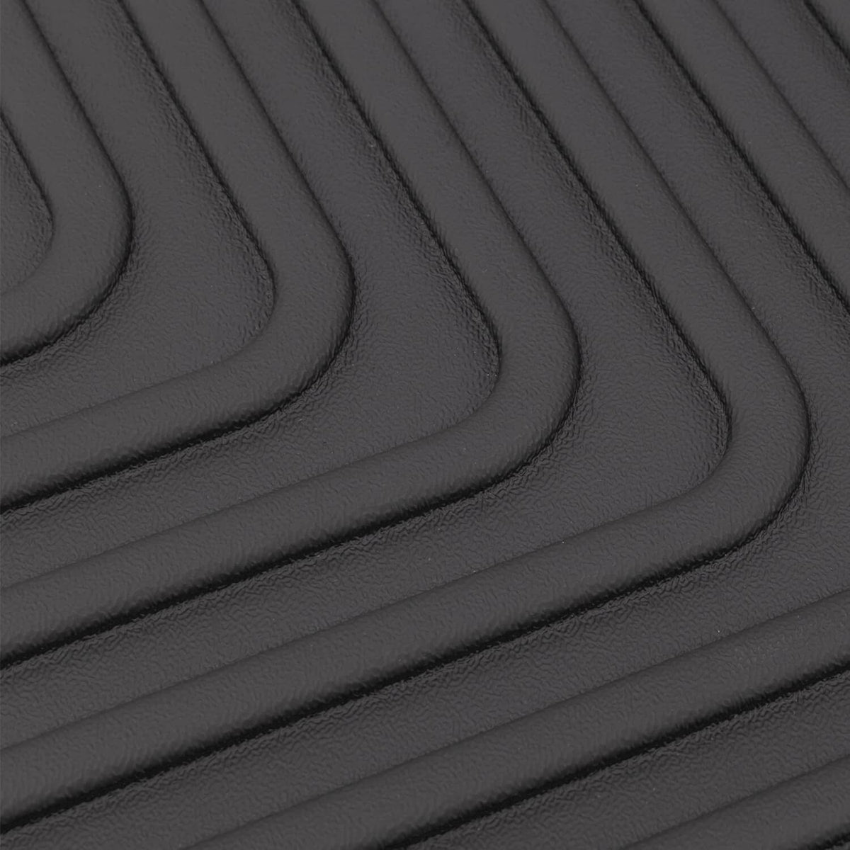 Black rubber floor mat with curved ridged grip channels