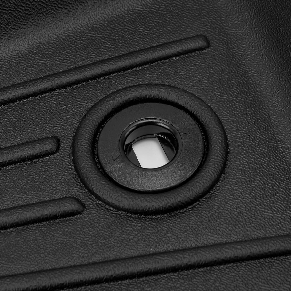 Black molded floor liner showing circular anchor grommet for securing