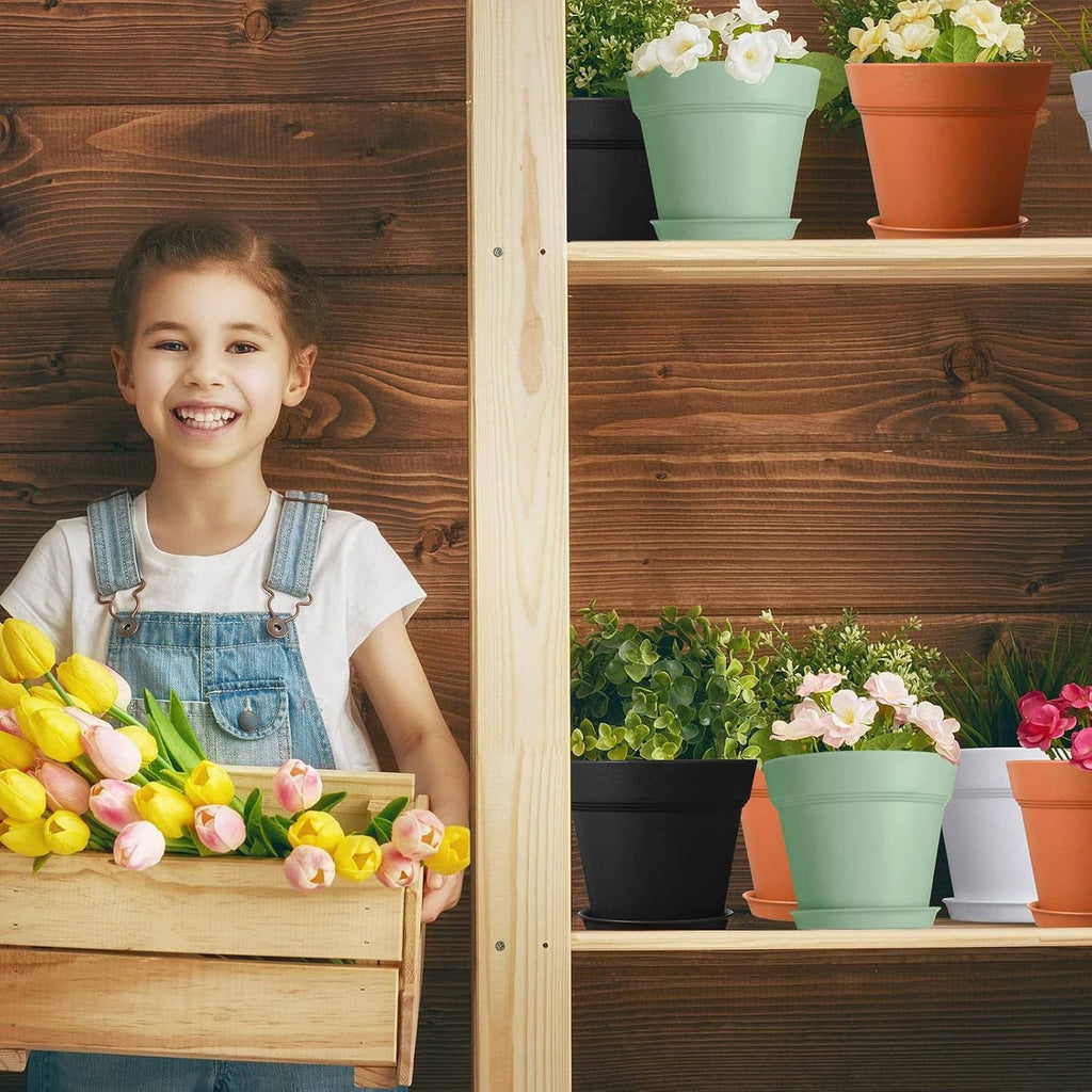 Assorted 4-inch plastic plant pots in green, orange, black, and white on a shelf.