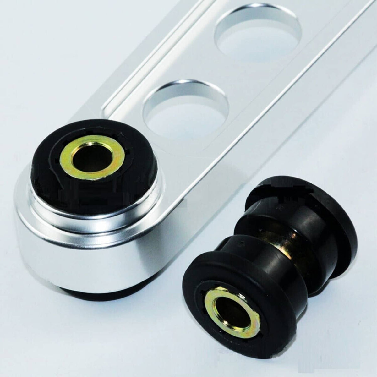 Lower control arm bushing kit with black rubber bushings and gold-tone metal sleeves