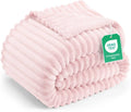 Pink striped fleece blanket, rolled and folded with textured plush ridges