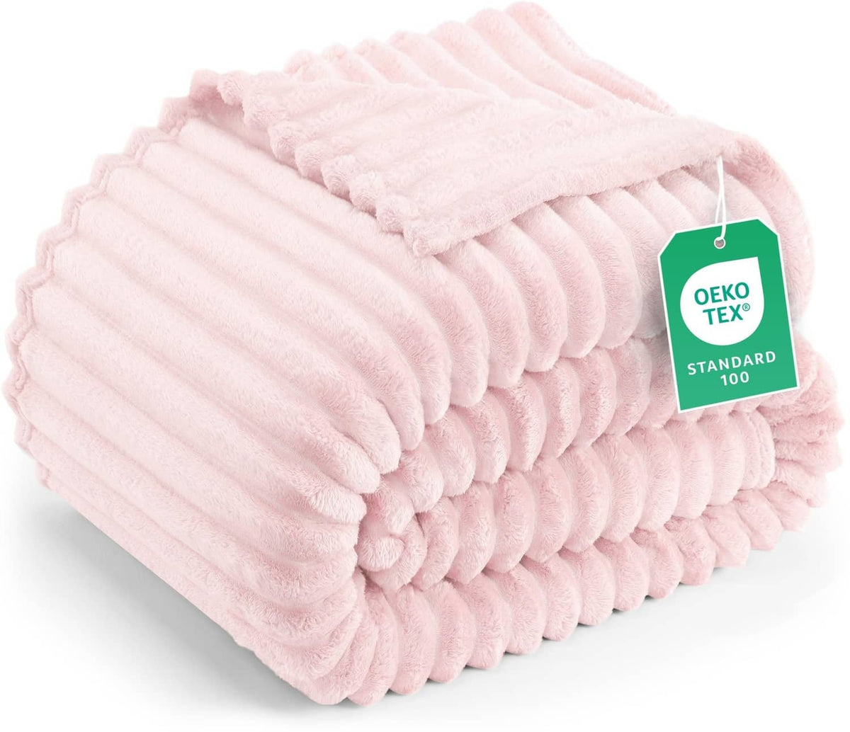 Pink striped fleece blanket, rolled and folded with textured plush ridges
