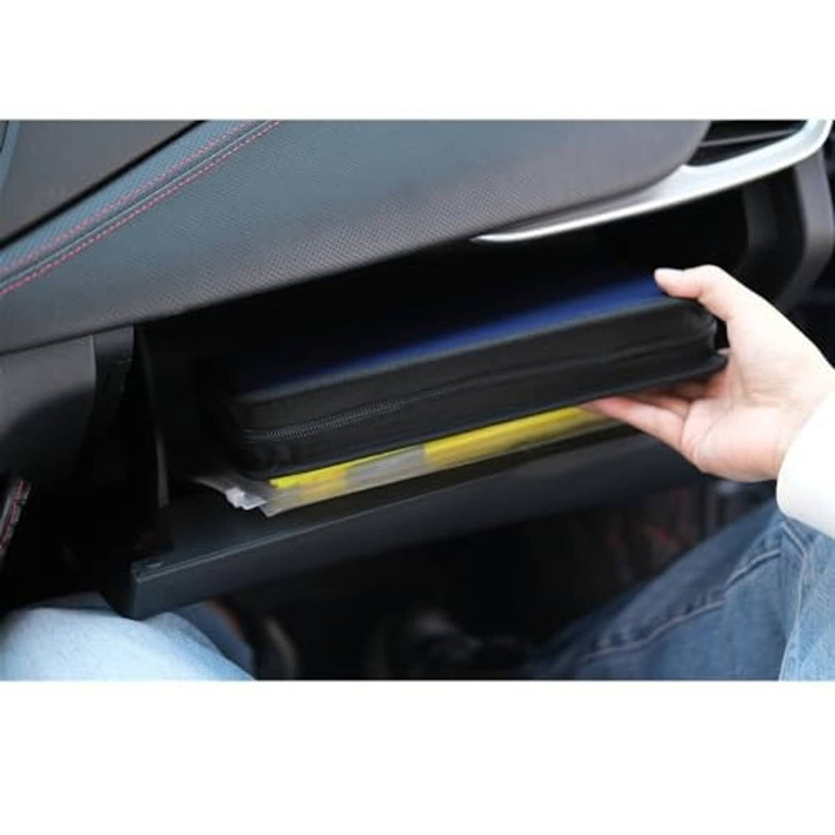 PU leather CD/DVD case partially pulled from car seat storage pocket, zipper closed