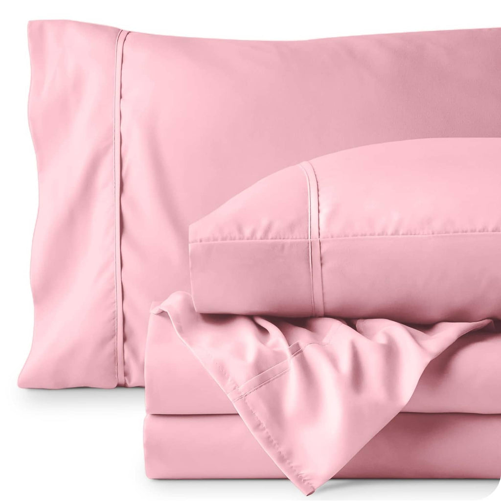 Light pink pillowcases and folded flat sheet with stitched edges and smooth fabric