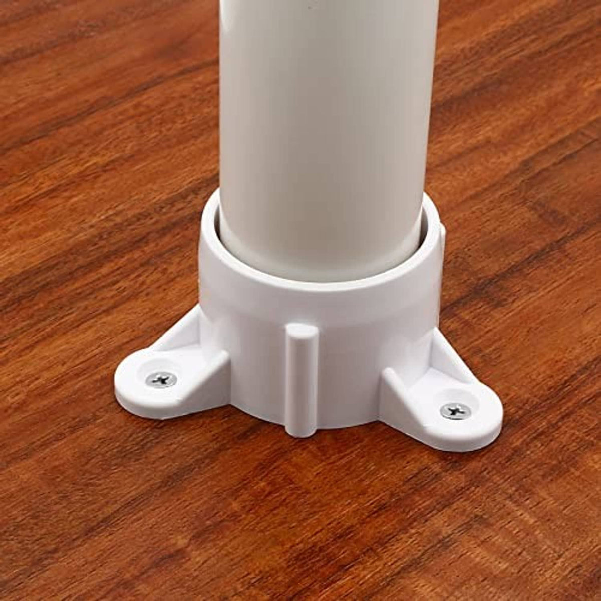 White PVC table leg cap fitting installed at the base of a wooden leg