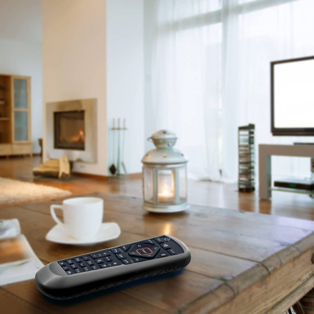 Gray remote control cover lying on a wooden table, slim protective case.