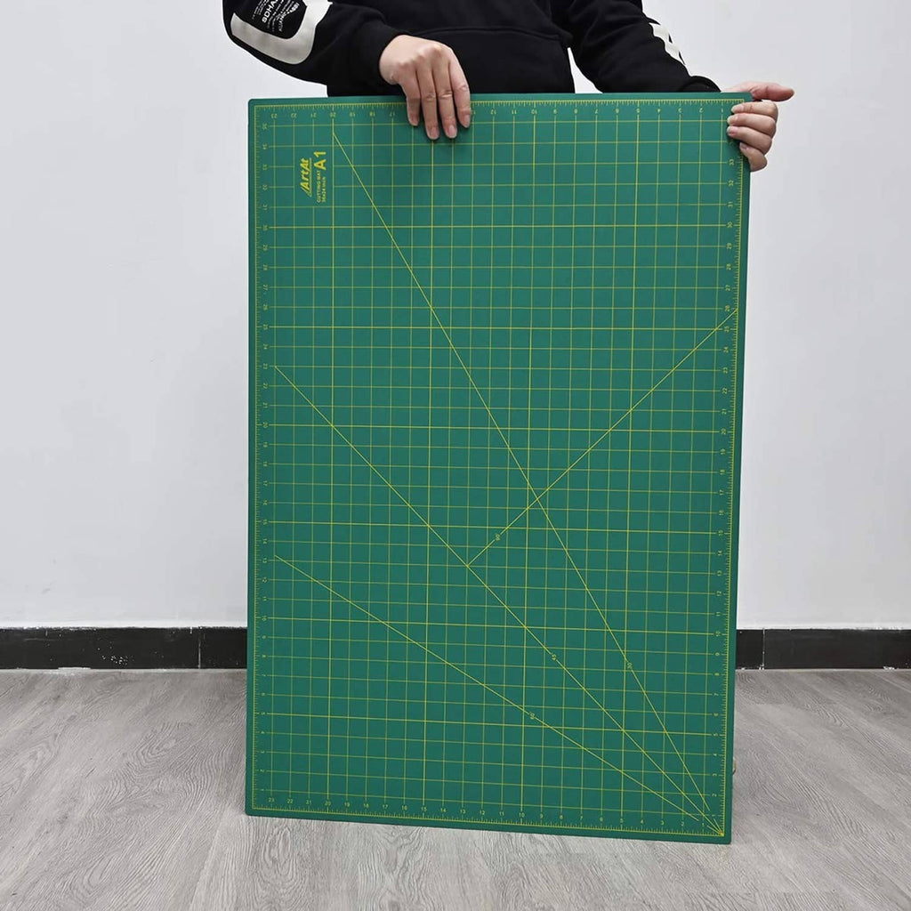 Large green self-healing cutting mat standing upright with measurement grid lines