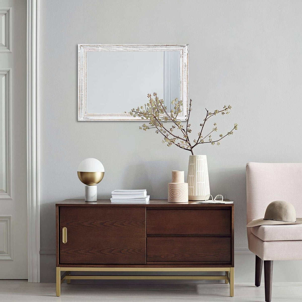Wall-mounted rectangular mirror with distressed white frame and reflective glass
