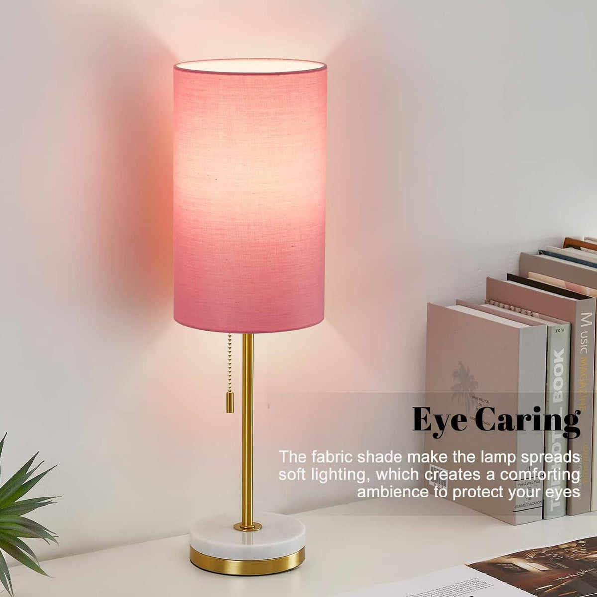 Minimalist table lamp with pink fabric shade, gold stem, and round white marble base.