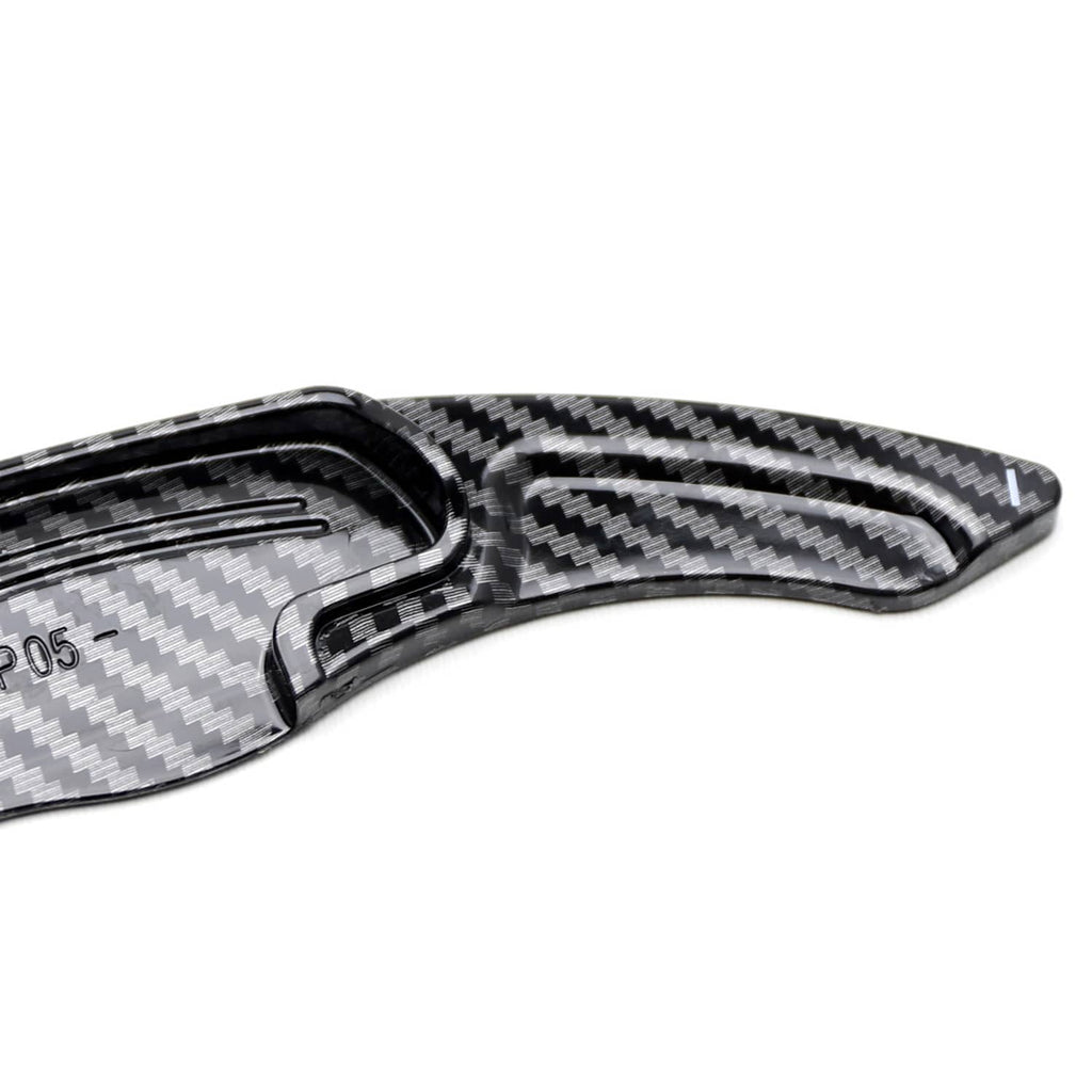 Carbon-fiber paddle shift cover close-up with textured grooves and channel