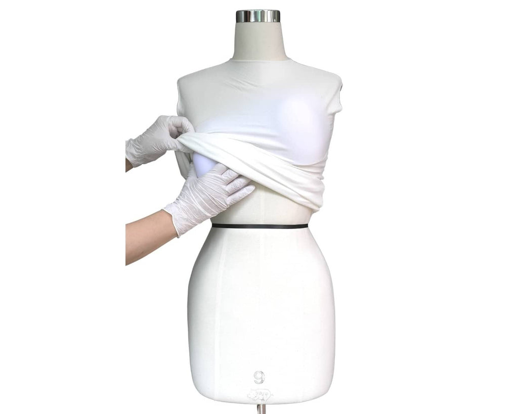 White stretch cover being wrapped around a dress form mannequin for padding setup