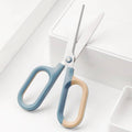 Craft scissors with blue-and-beige comfort grips and silver blades, angled view