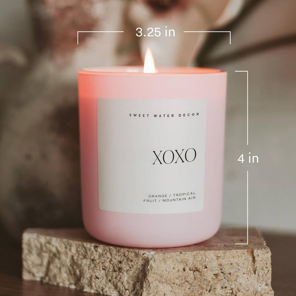 Pink-orange soy jar candle with “XOXO” label and flame, 3.25 in x 4 in