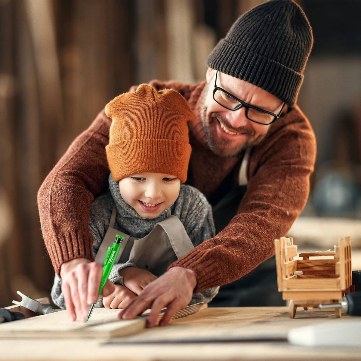 Adult and child writing with green pencil refills on a wooden workpiece