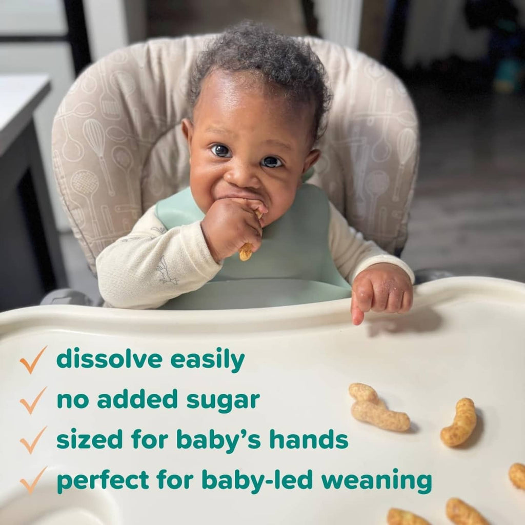 Baby in high chair with peanut butter puff snacks; sized for small hands