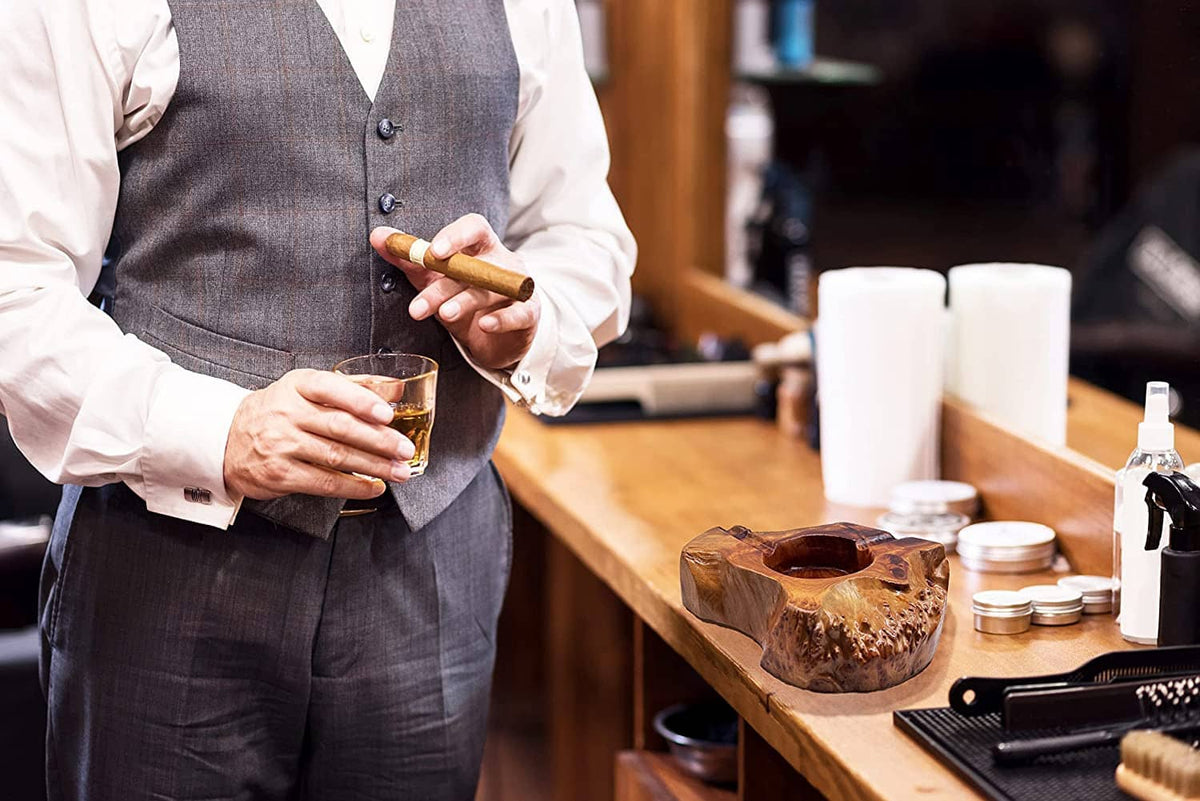 Wooden cigar ashtray with carved circular bowl and cigar channel, on bar counter